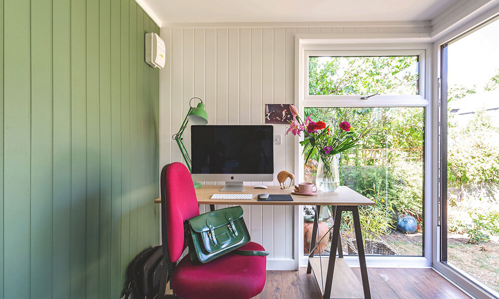 Interior of a small garden office with desk and computer 