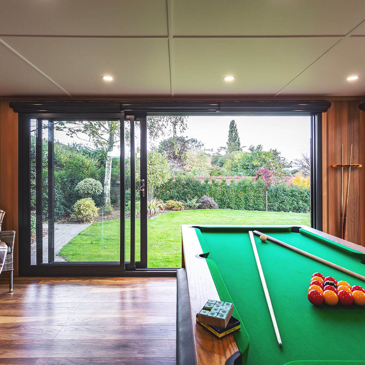 a pool table in a man cave garden room with sliding glass doors 