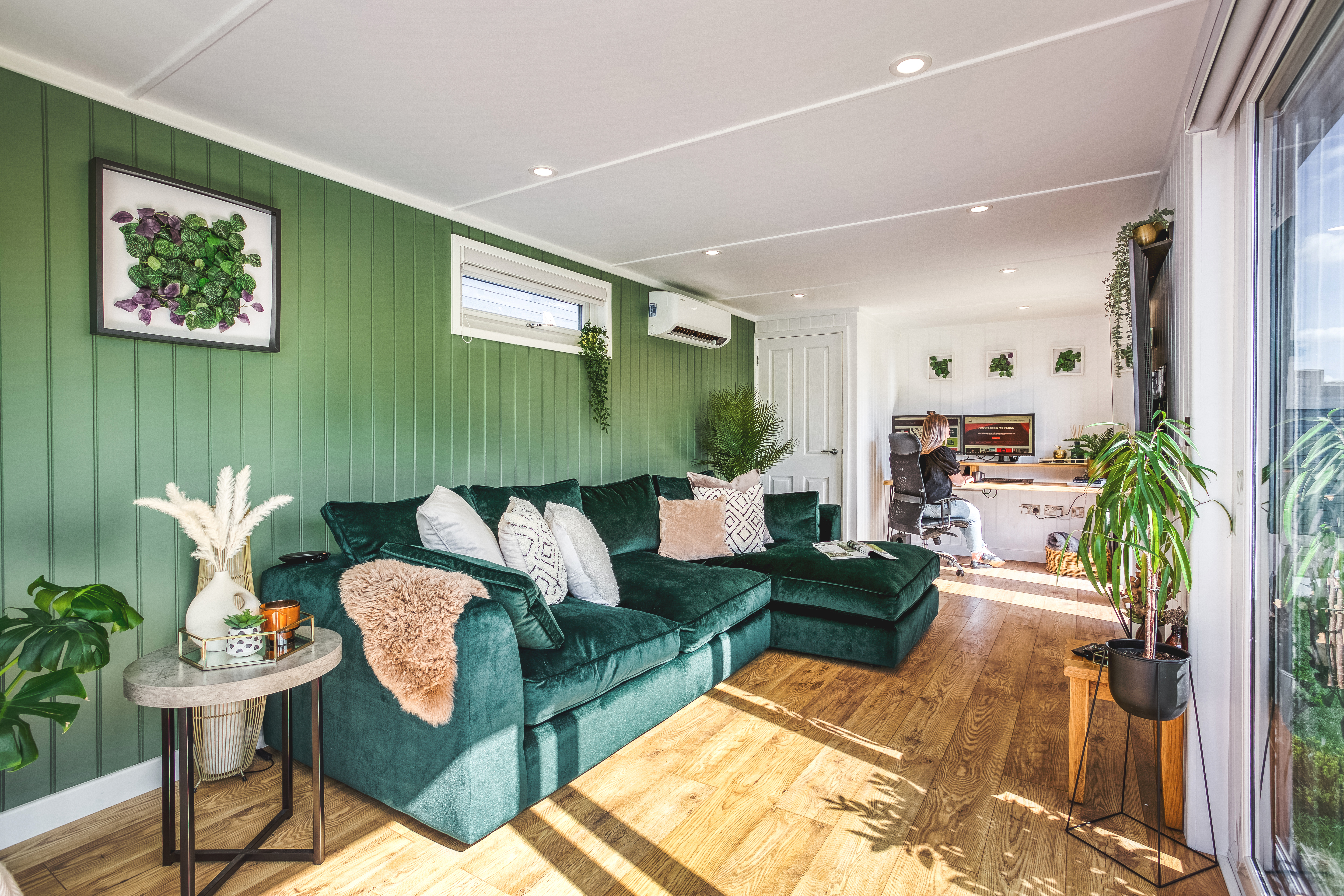 Large summerhouse office pod interior with green velvet sofa