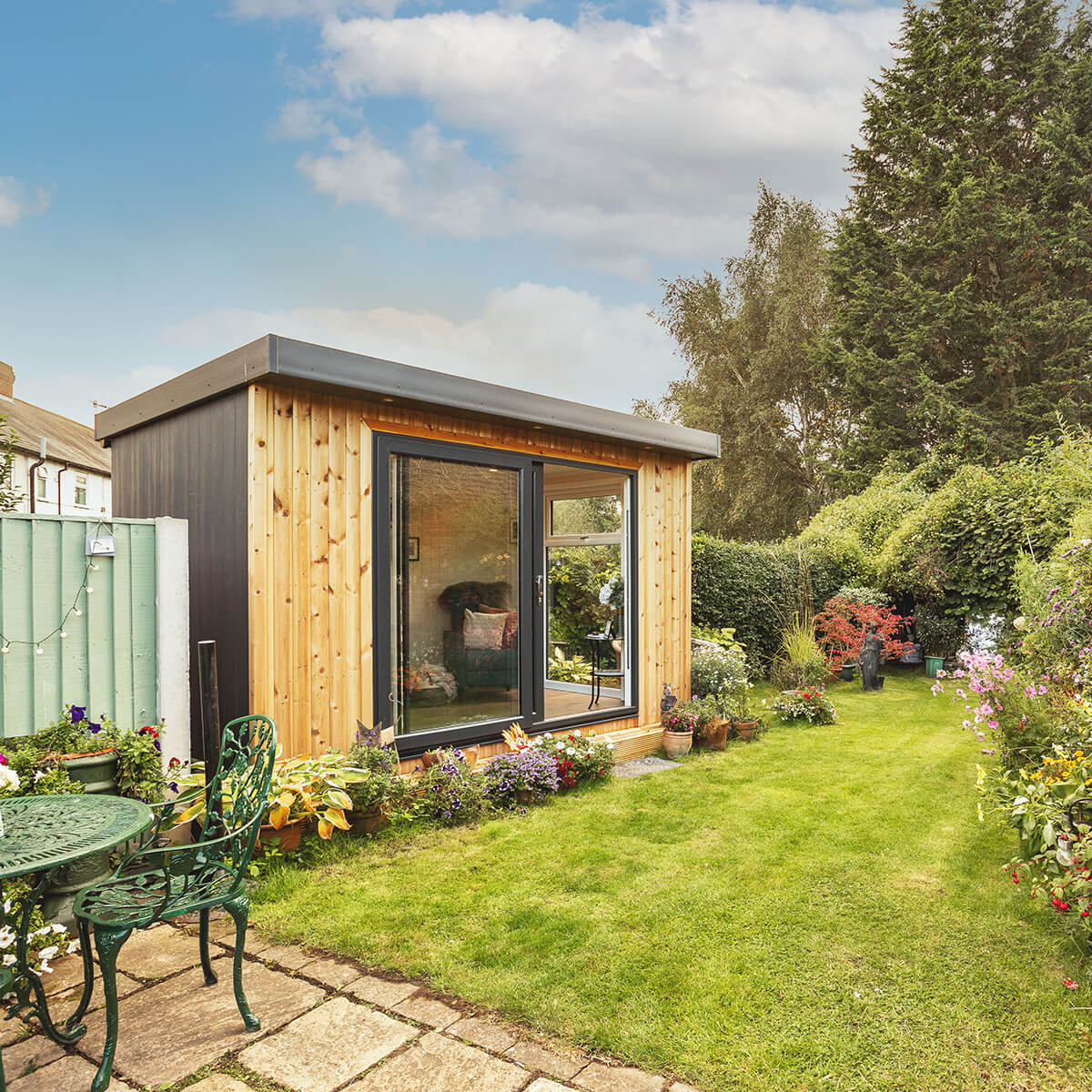 small garden summerhouse in outdoor area with potted plants and outdoor furniture with chair and tables 
