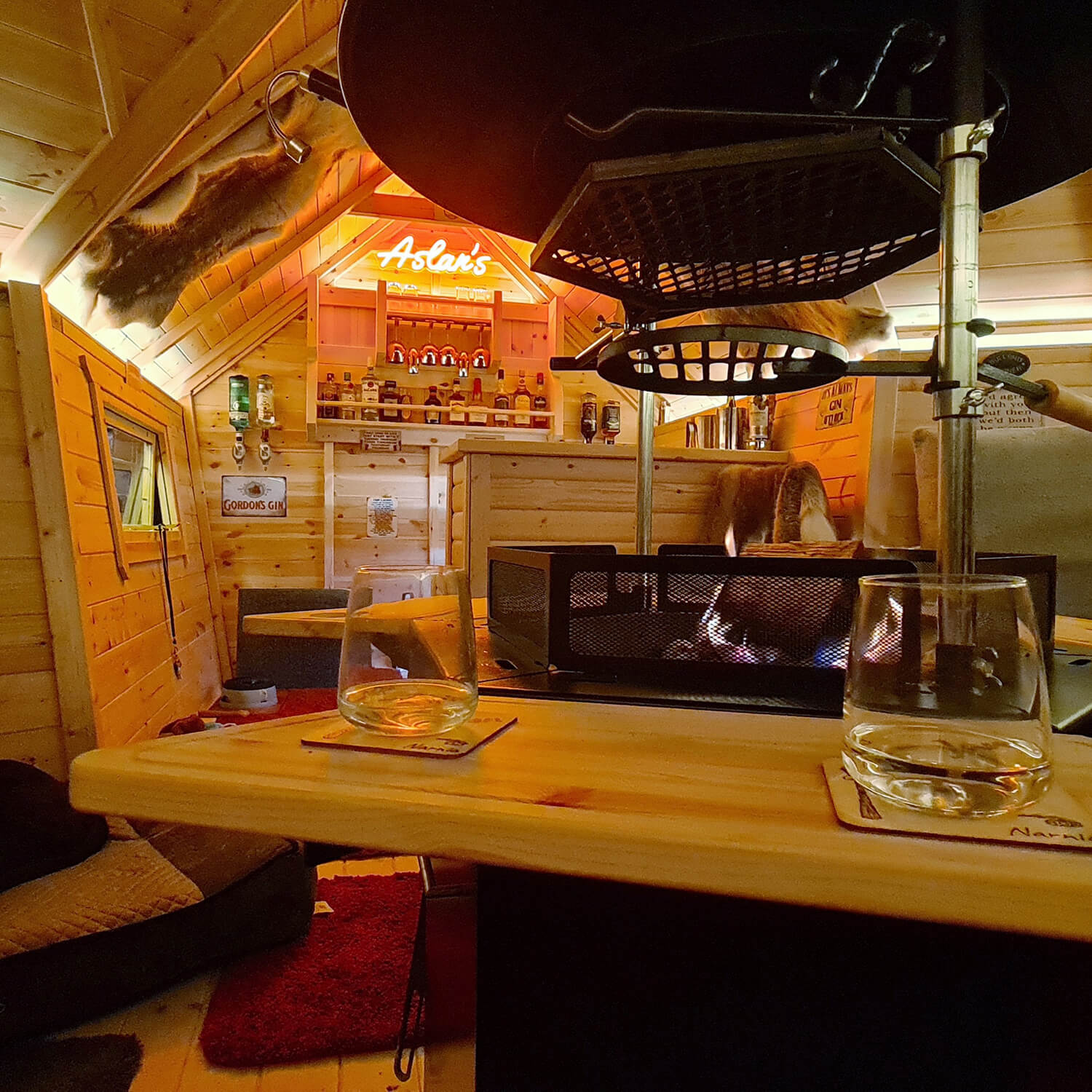 Internal shot of a BBQ garden bar with neon sign behind bar