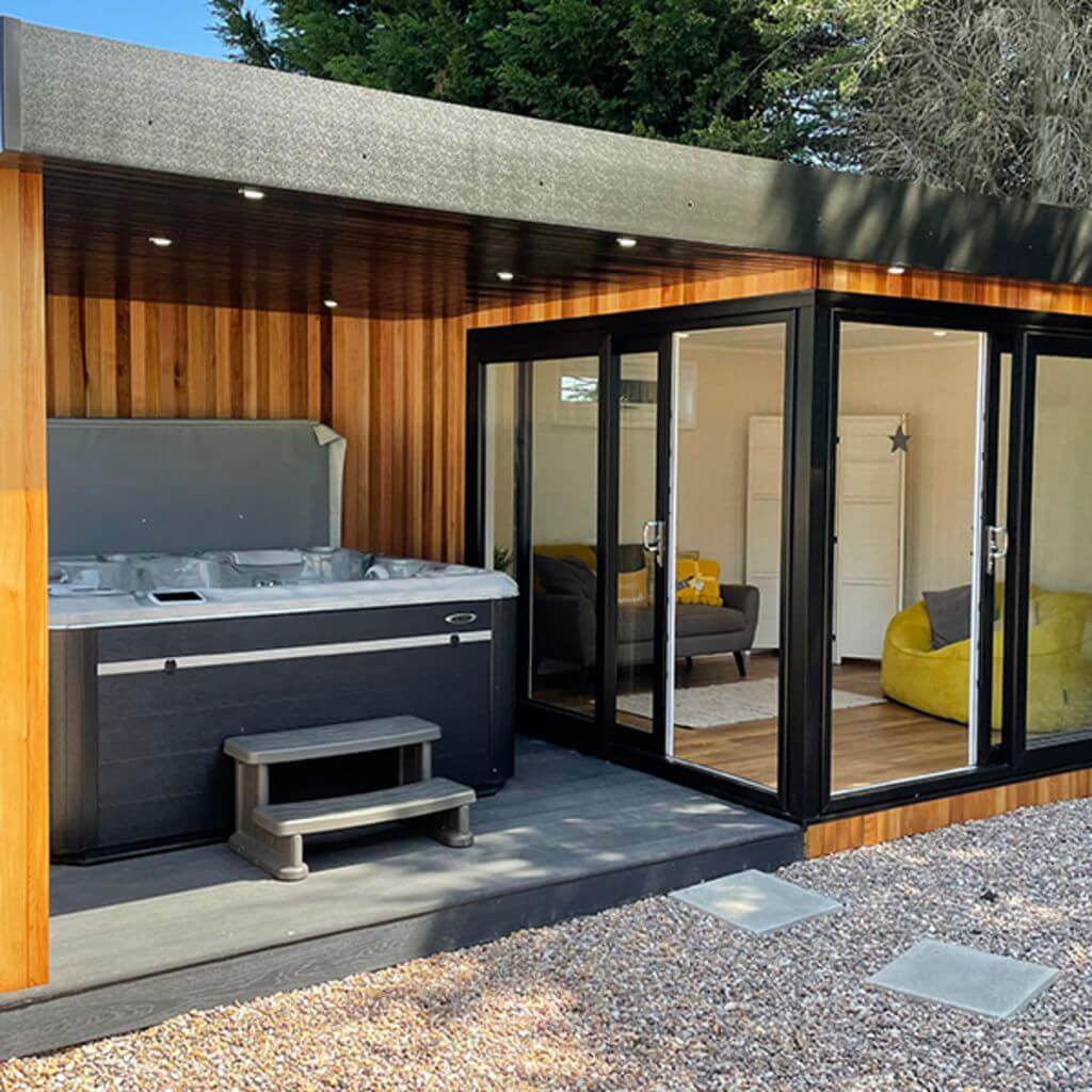 Show Site Veranda Room cedar Cladding garden building with veranda and hydropool midlands hot tub and view into building with grey and yellow home furnishings  