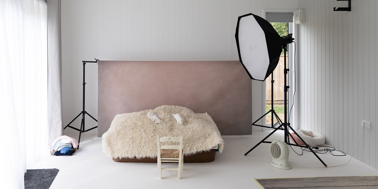 Home photo studio in garden, interior shot with backdrop, lighting and props  