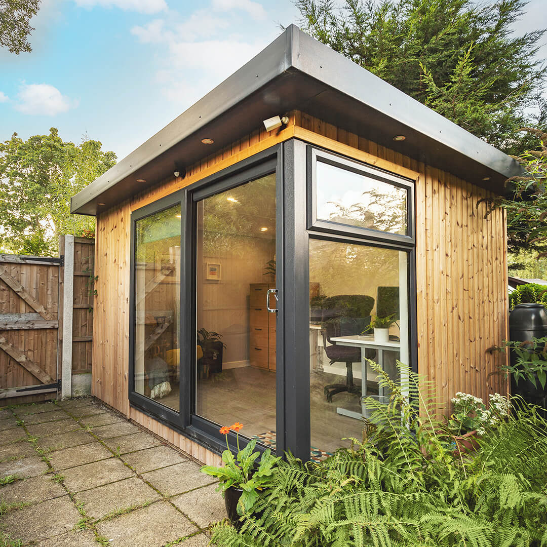 Redwood Garden Office in patio area with green lawn and hedges