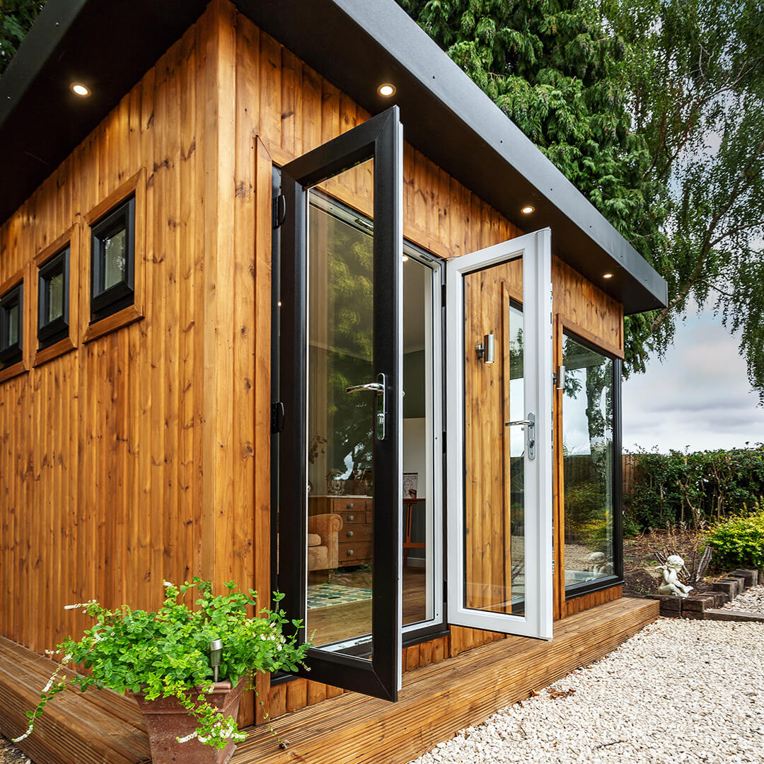 redwood garden room hobby and craft studio with french doors and  potted plants