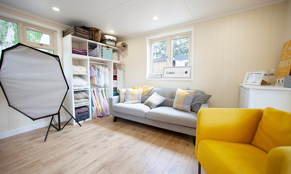 Interior of a garden room photography studio with yellow and lighting equipment