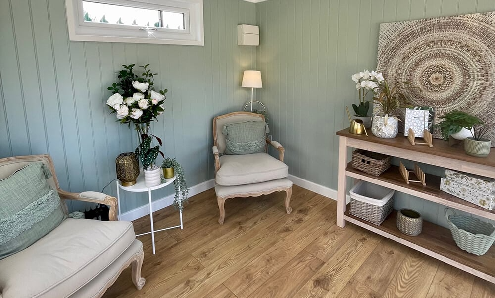 Interior of a garden room snug with comfy chairs and homely decor