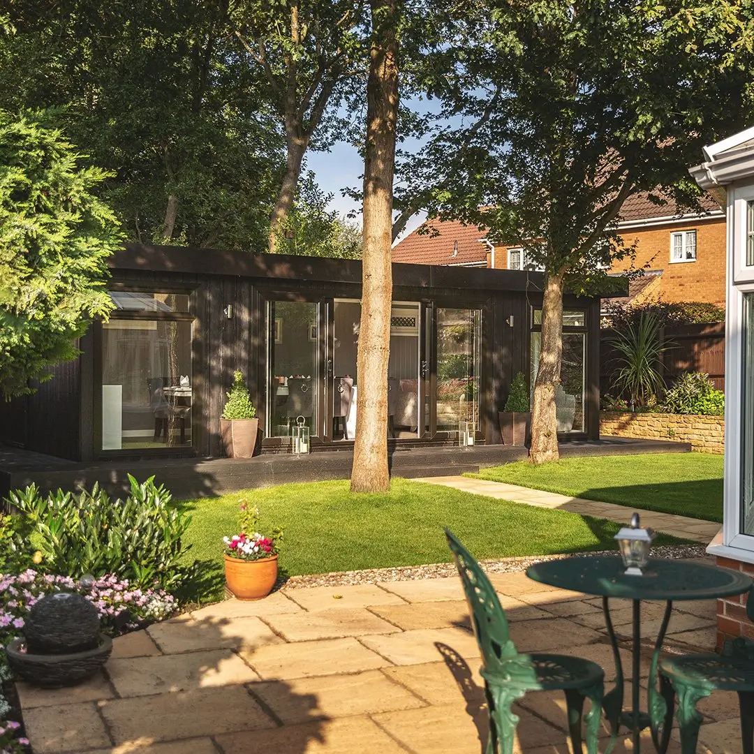 large marley board dining room with oak trees in front and patio pathway with lawn area