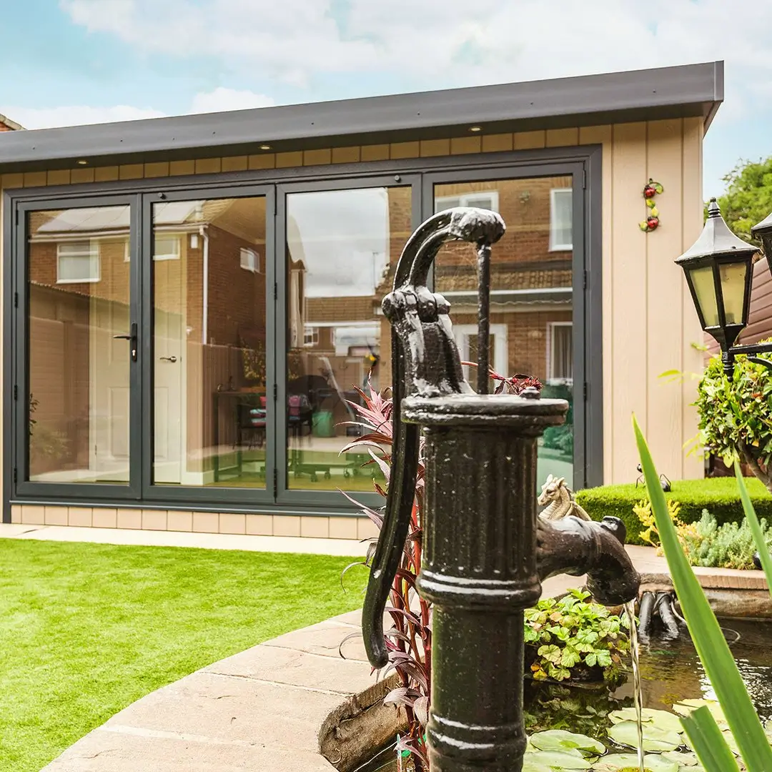 Cabin Master Marley Shoffice Garden Room with water feature in grassy lawn area