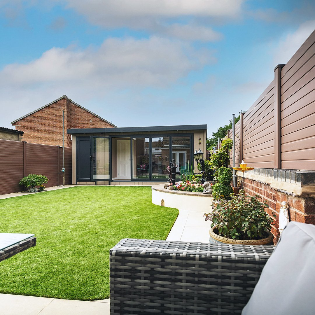 Large shoffice building in grassy lawn area with patio path and potted plants