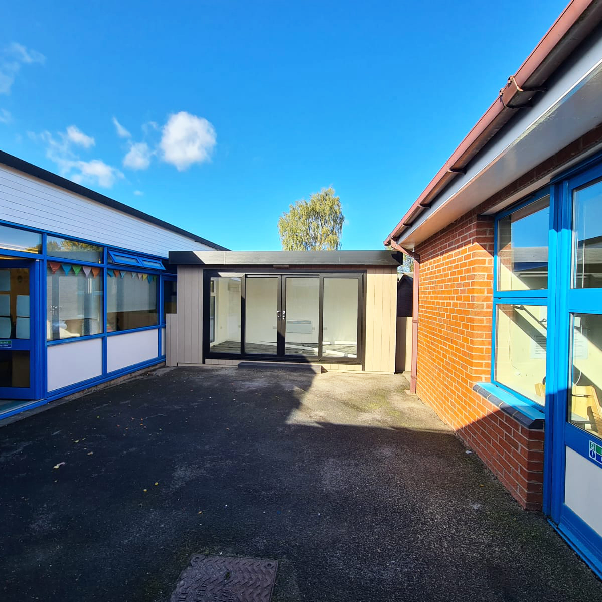 School cabin building on playground next to traditional school building