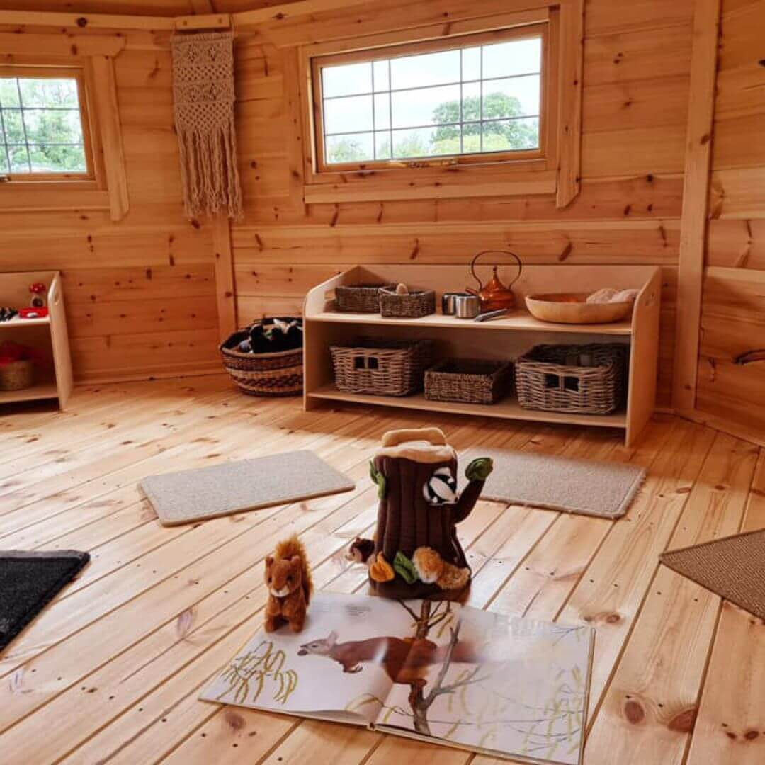 Cabins For Schools Happy Homestead Nursery inside view with nature book and toys and cubby hole with rattan baskets and furnishings