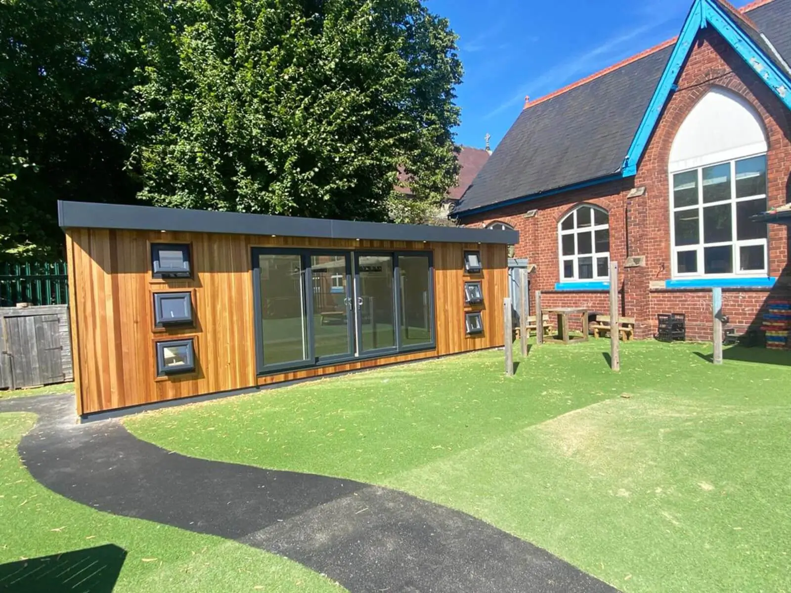 Cabins For Schools Valley Nursery School Cedar Hybrid in playground with path and school building