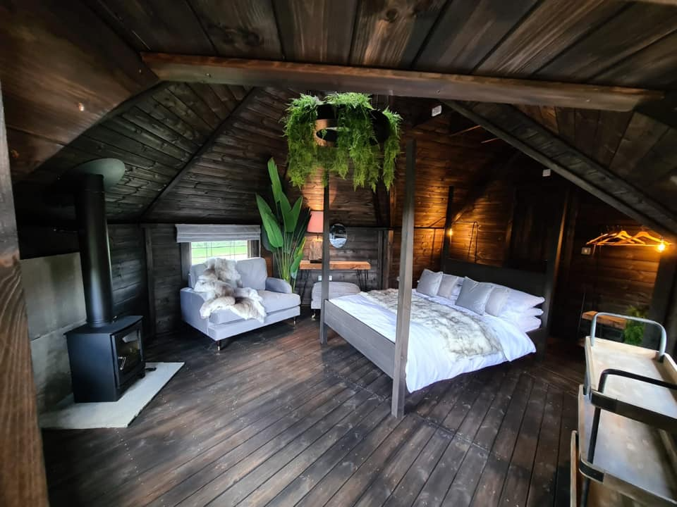 Luxury timber glamping cabin with tropical plants and cosy decor