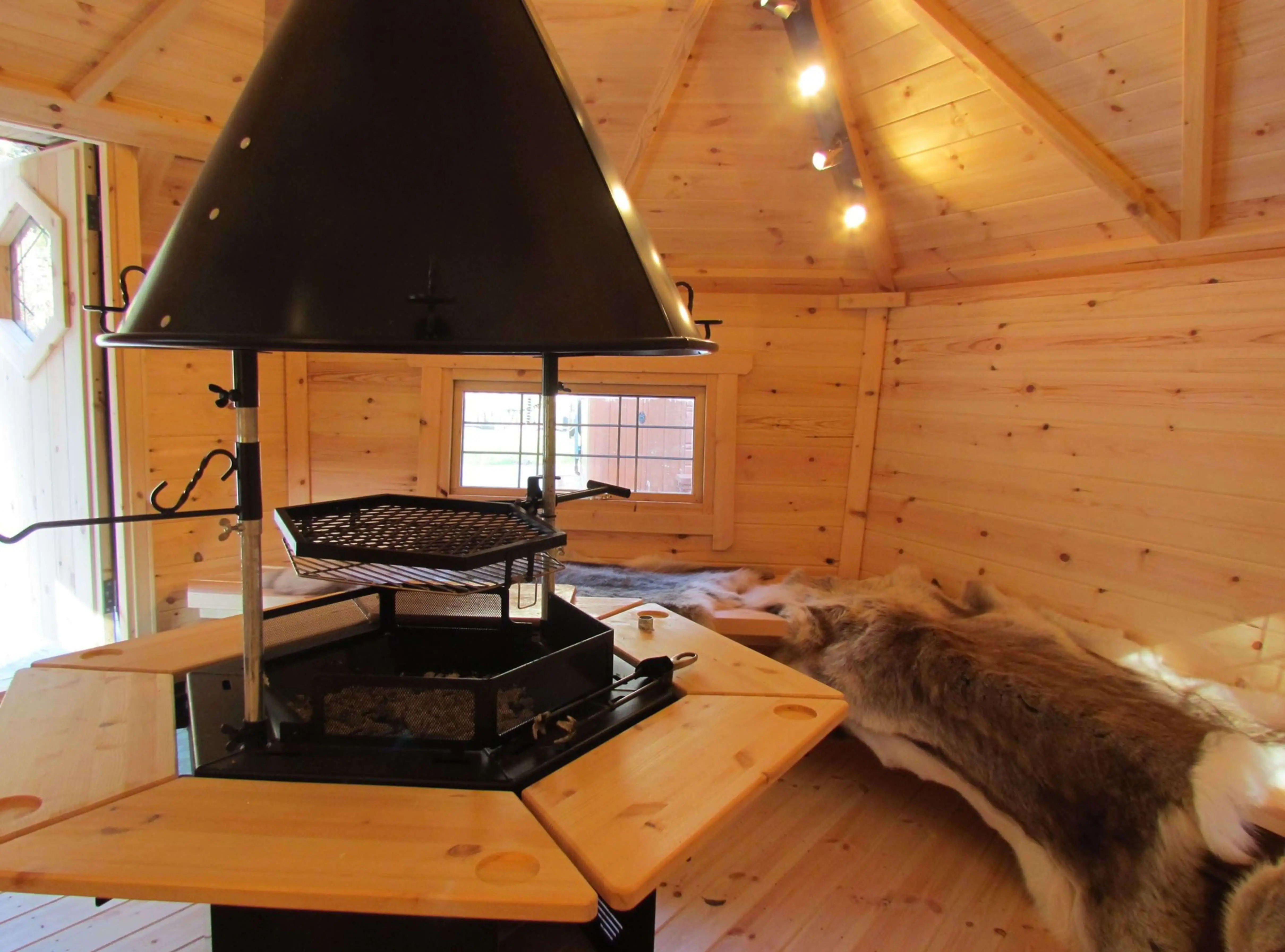 camping cabins inside view with bbq and reindeer skins and led lights grillkota hut