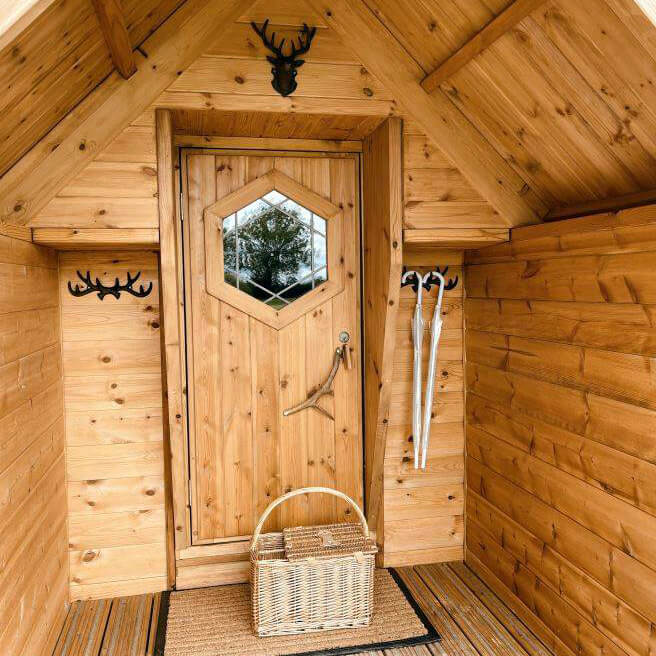 Entrance porch of a rustic Scandinavian log cabin for glamping