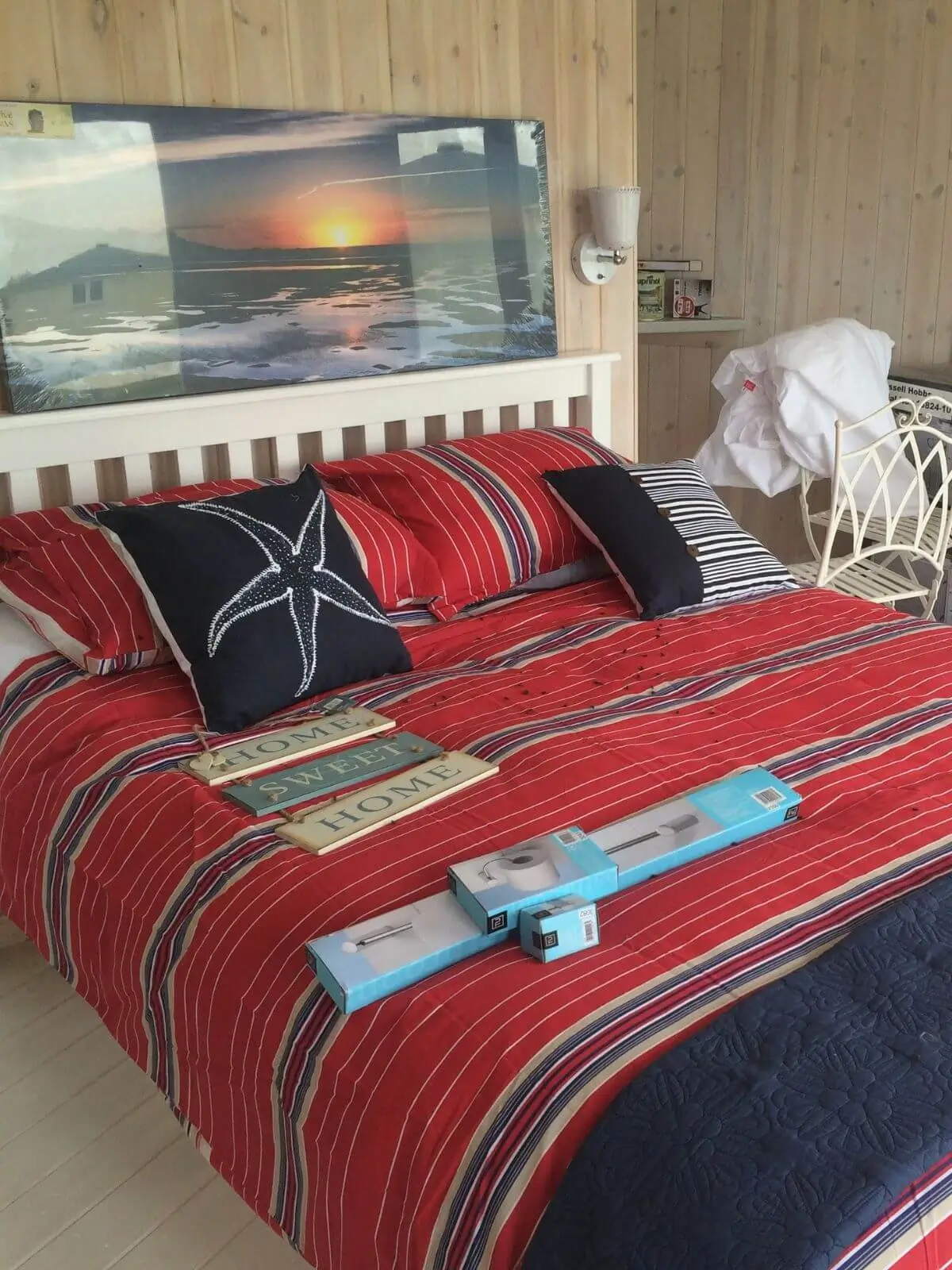 inside view of camping cabin glamping lodge with double bed and blue and red starfish themed bedding and landscape wall hanging