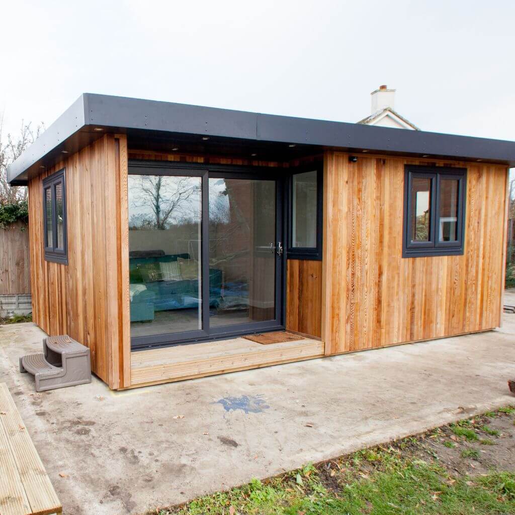 cabin master garden room annexe on composite patio area with green lawn area and view into lodge