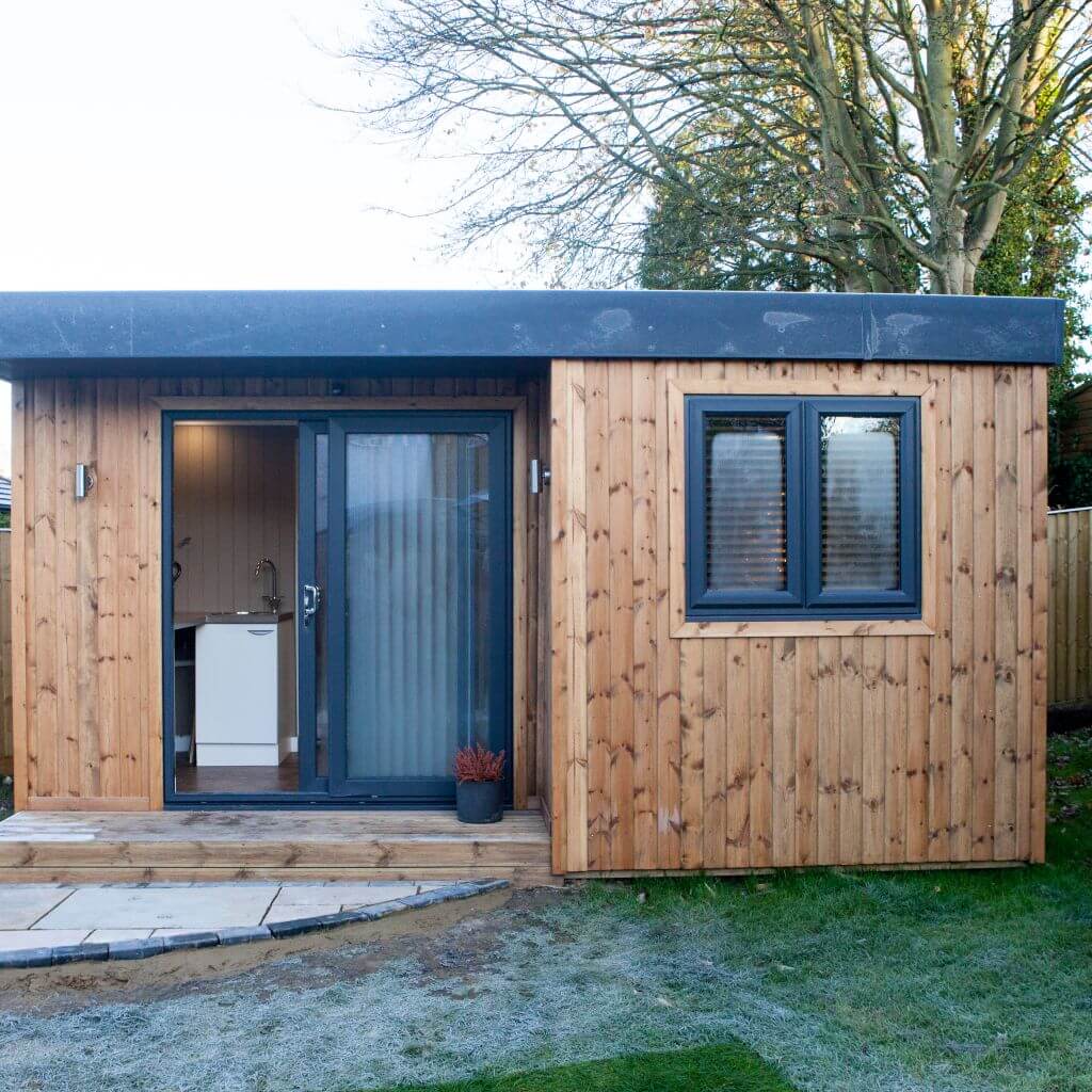 redwood garden room home spa in grassy lawn area with timber step on patio area