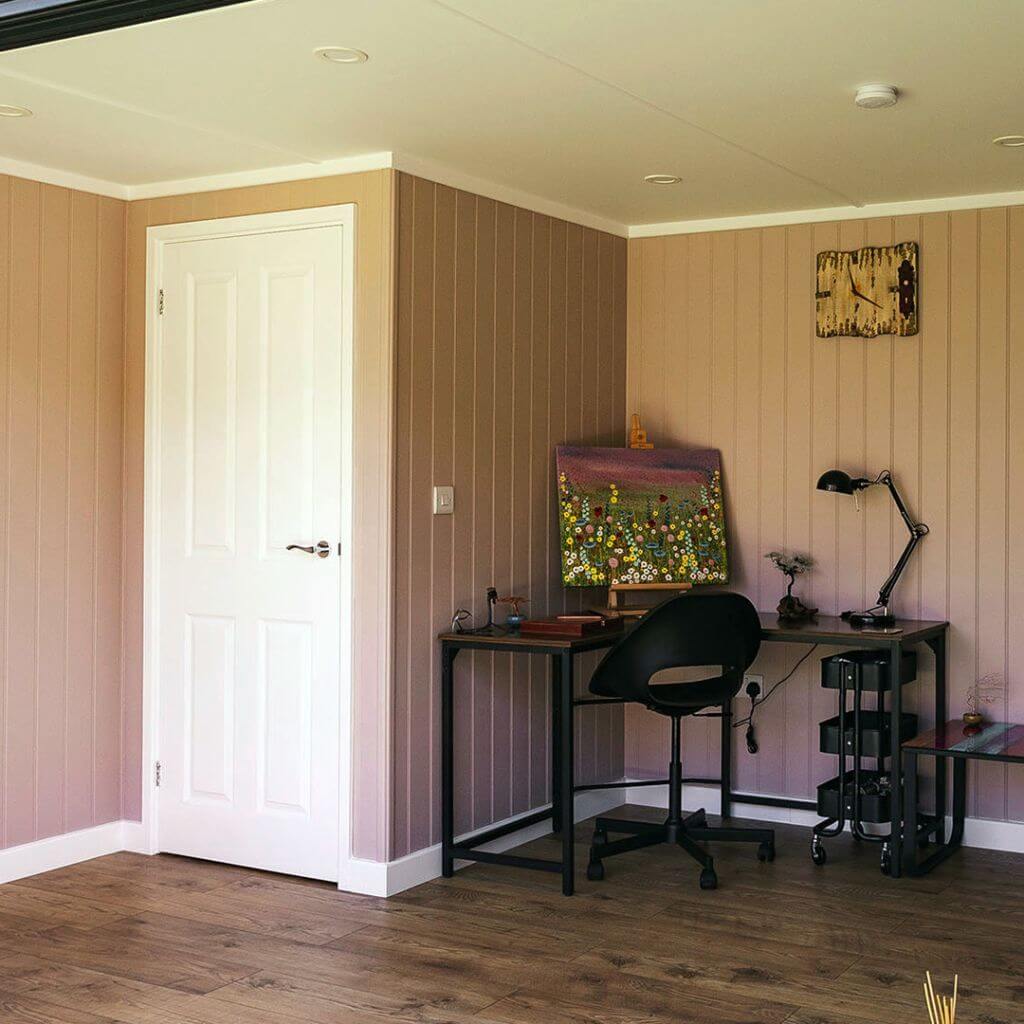 view of desk and chair and large painting and lamp with internal partition door