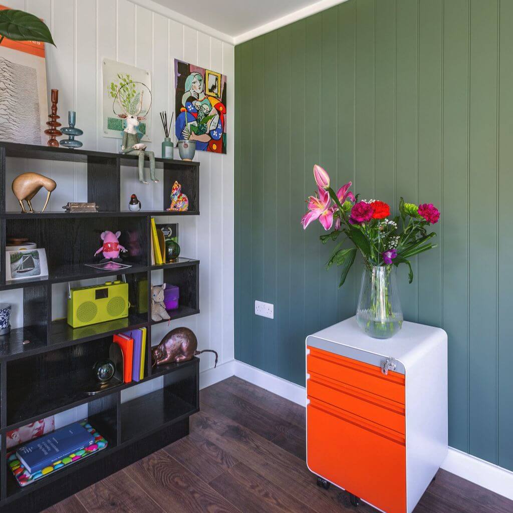 garden office building with shelving and paraphernalia with a chest of drawers with vase on it 