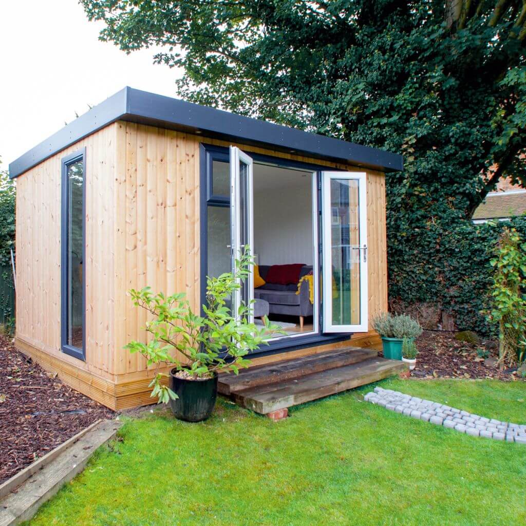 small garden pod in lawn area with patio walkway and potted plant and open doors 