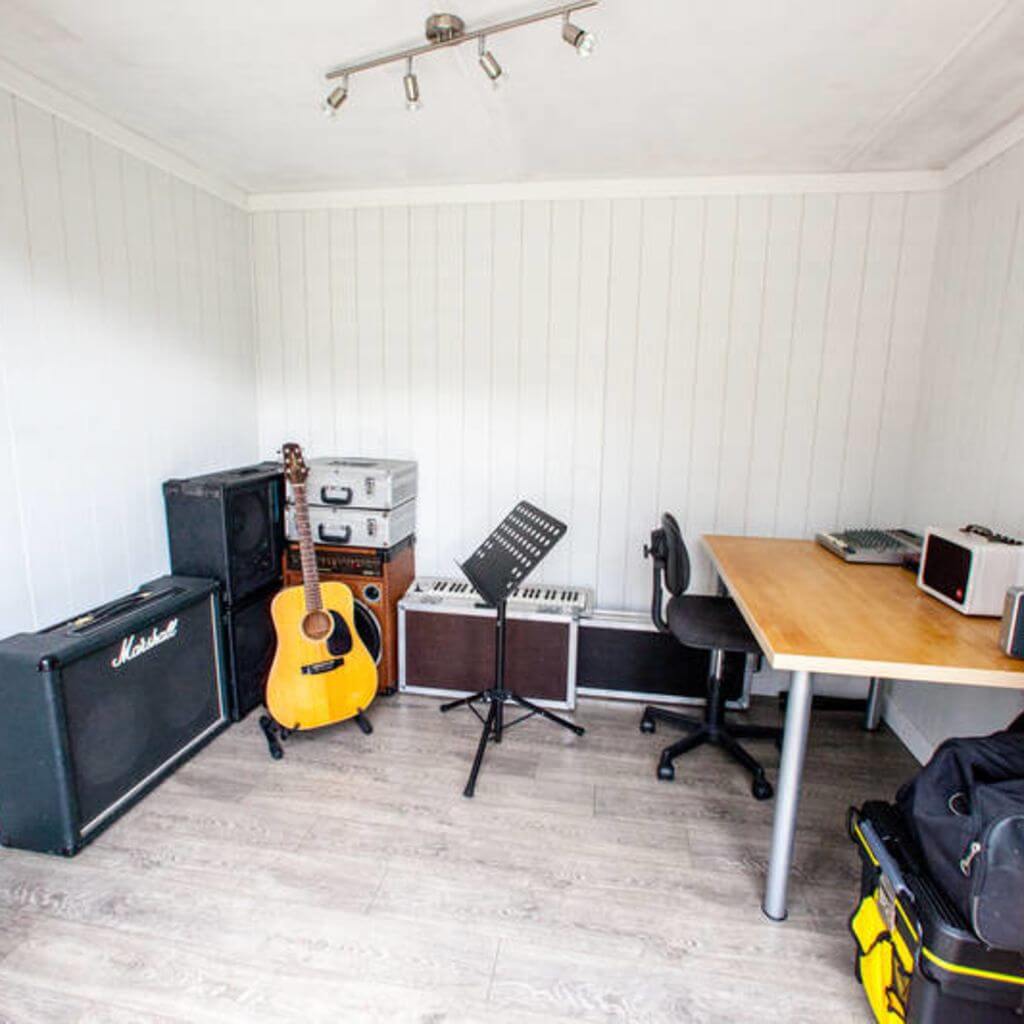 garden music room with guitar and sheet stand and desk with speakers