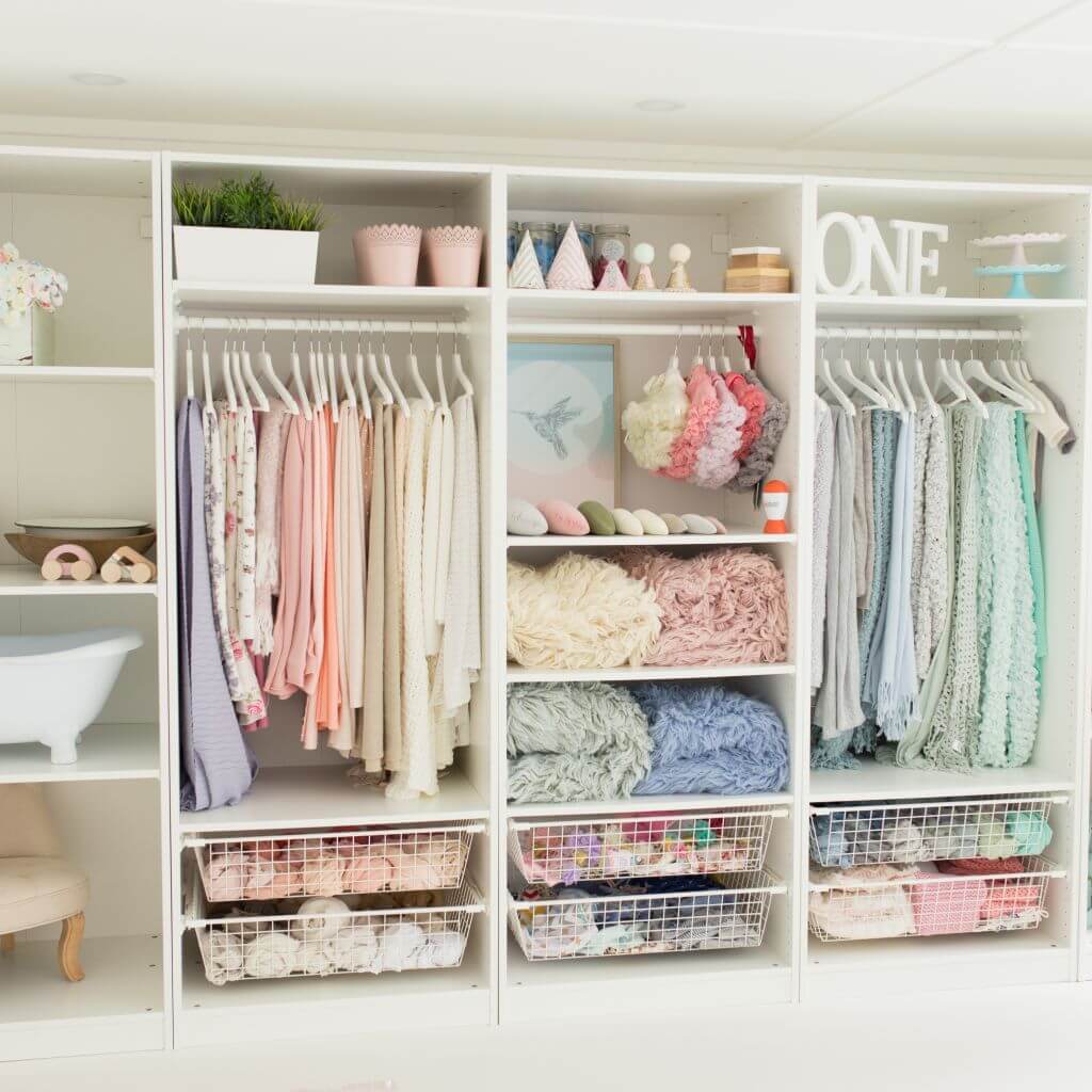 large wardrobe inside photography studio with assortment of clothing and trinkets in pastel colours 
