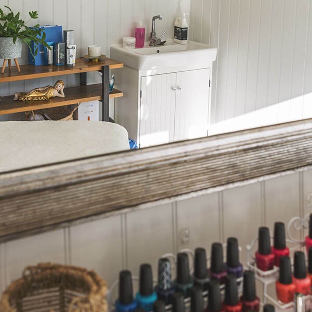 garden beauty room studio with large mirror and rows of nail varnish 
