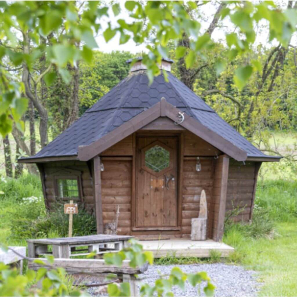 camping cabin eco pod at the hideaway at baxby manor in field with bench outside