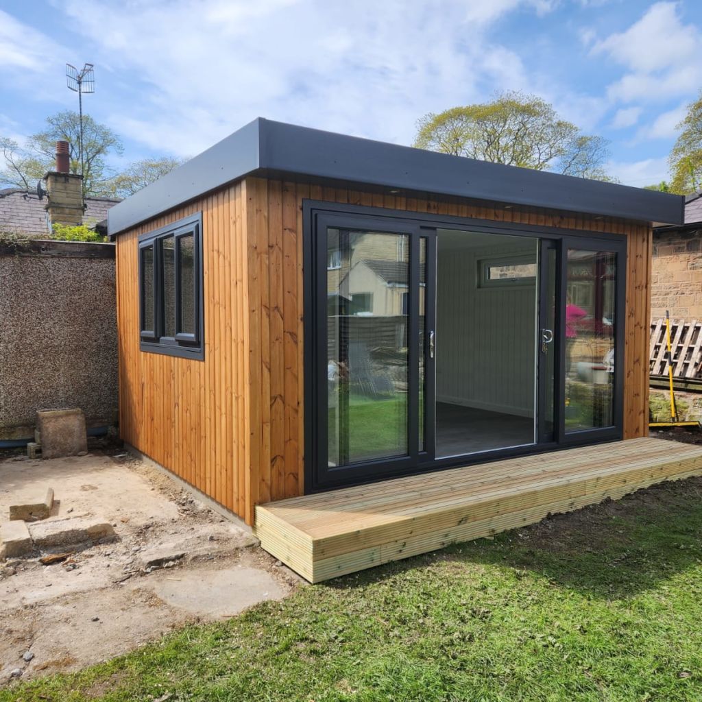 redwood garden room with timber step in lawn area with black fascia