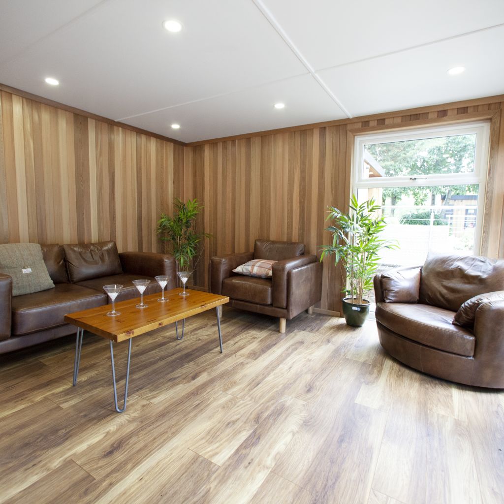 inside show site entertainments room with coffee table and cocktail glasses on it with leather sofas and armchair