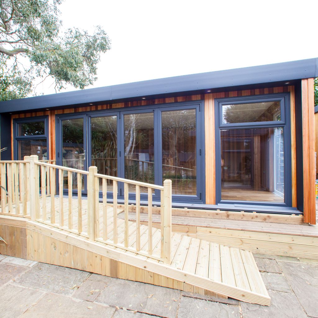 large cedar garden room with black fascia and timber ramp in front of it 