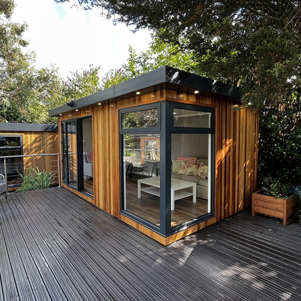 large cedar garden room on nottingham show site with timber decking and planter next to it