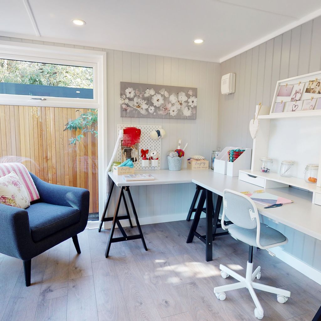 large white desk with blue armchair and notebook on table