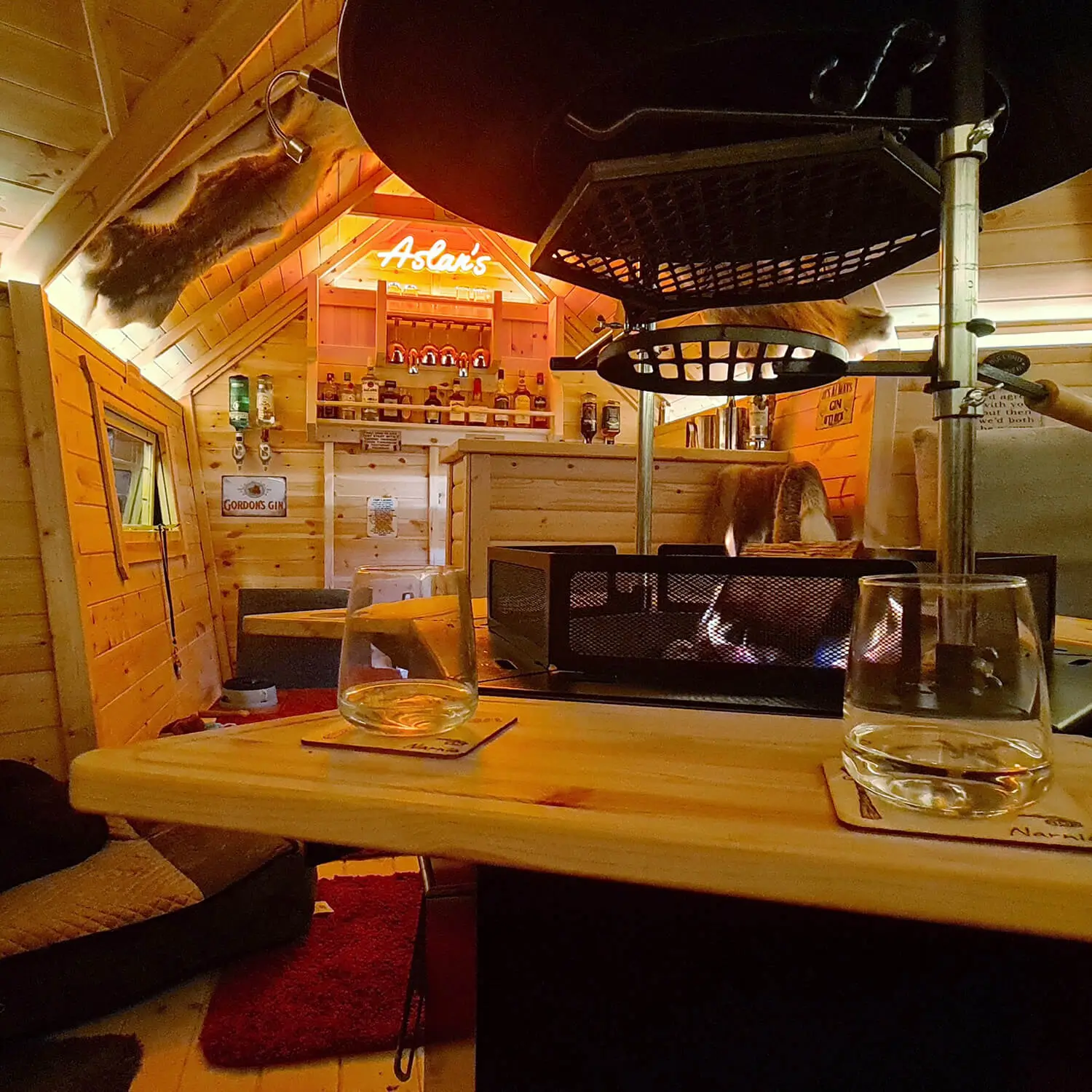 Internal shot of a BBQ cabin bar with neon sign and whiskey glasses