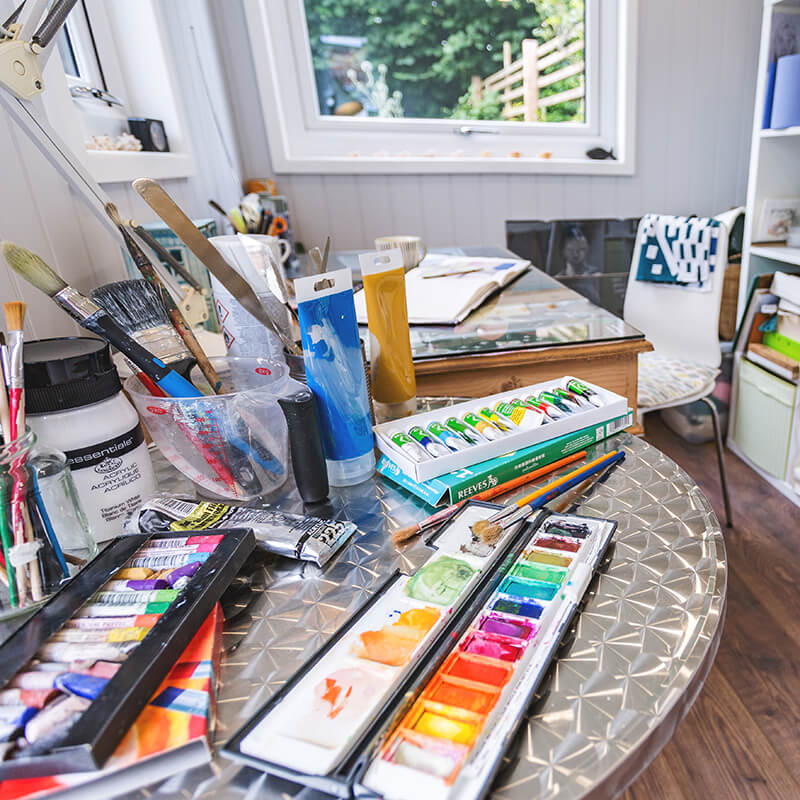 close up cabin master garden room artists studio with laminate flooring and acrylic paints and brushes and storage unit