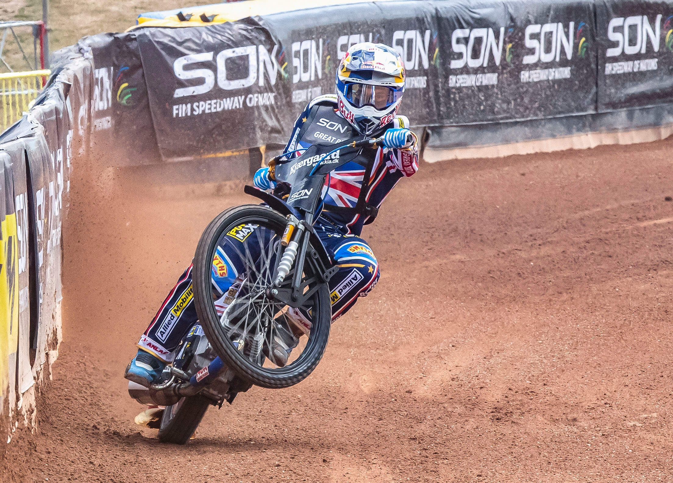 Speedway Of Nations 2022 Man On Motorbike Action Shot on Dirt Track with Fencing and Banners