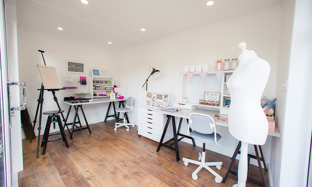 Interior of a garden craft room with mannequin and various desks with sewing equipment on