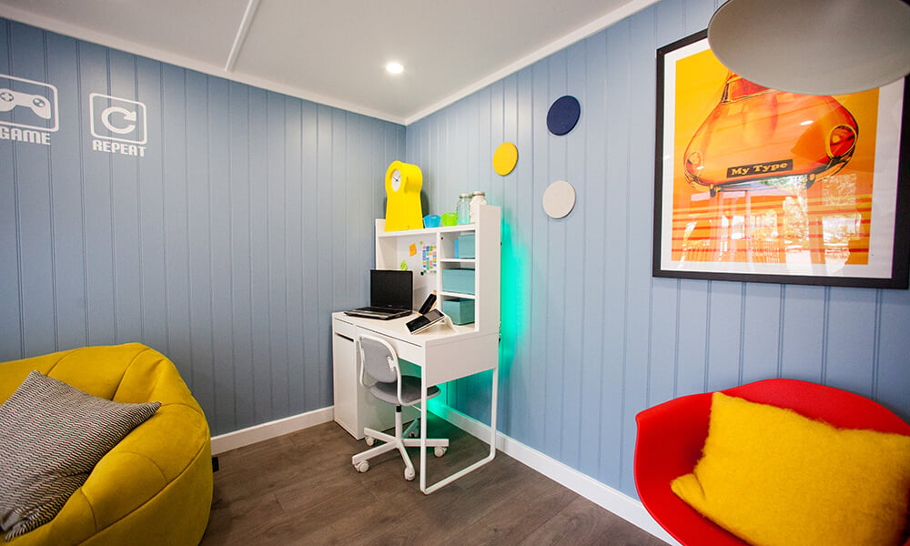 Garden room teen den with light blue wall and brightly coloured decor