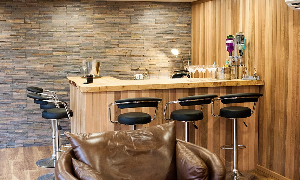 Interior of a cedar internally cladded garden bar with bar area, stools and drinks optics
