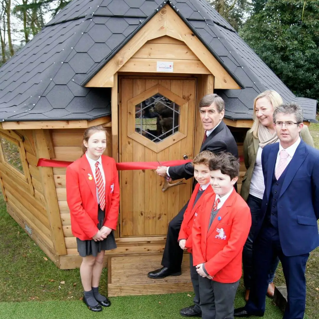 Cabins For Schools with black roof redwood building with students and mayor and red ribbon cutting 